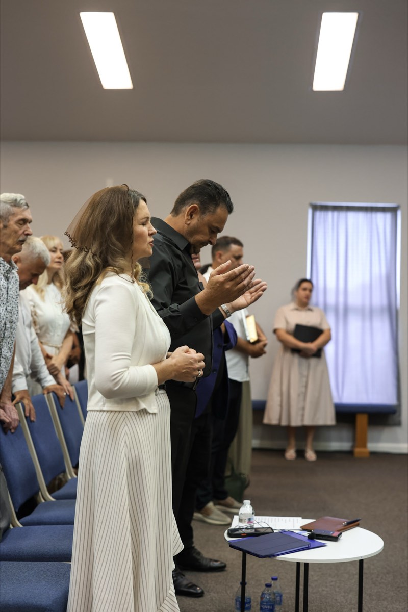 Church members praying together with a family at the front