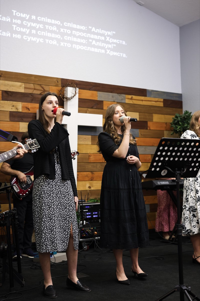 Two hosts speaking to the church from the front