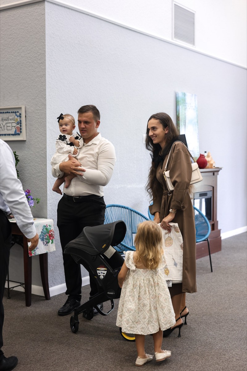 A couple with their young child after a service