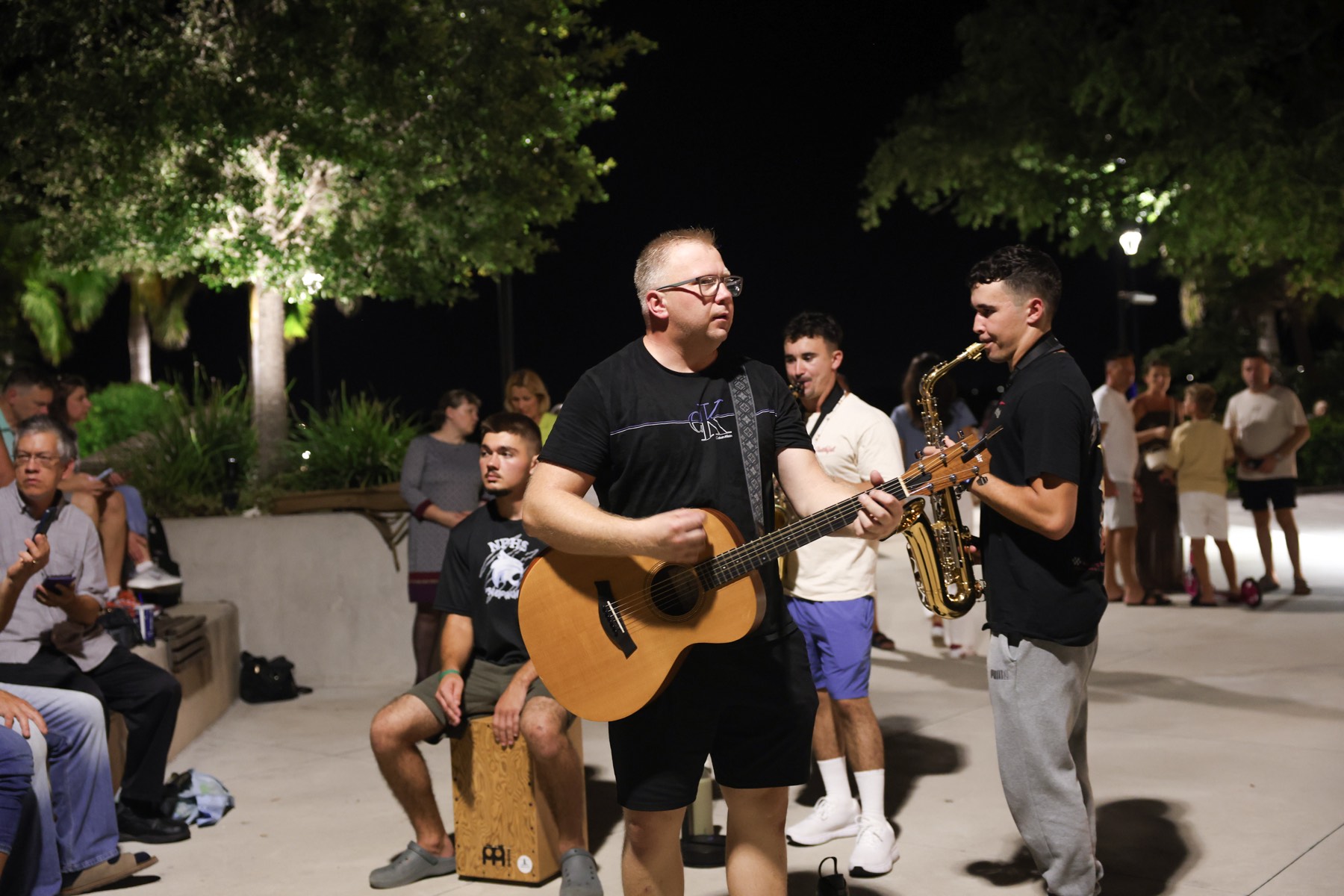 A guitarist leading songs as people gather around